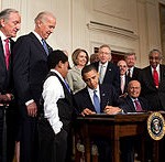 220px-Obama_signs_health_care-20100323